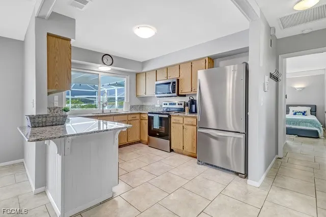 a kitchen with stainless steel appliances granite countertop a refrigerator sink and stove