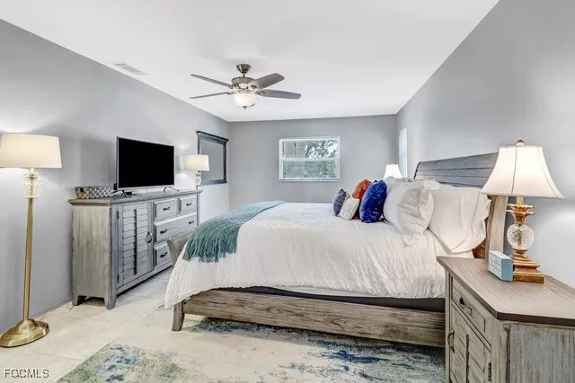 a spacious bedroom with a bed and a flat screen tv