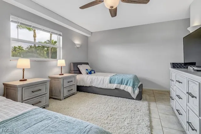 a bedroom with a bed and a flat tv screen on the dresser