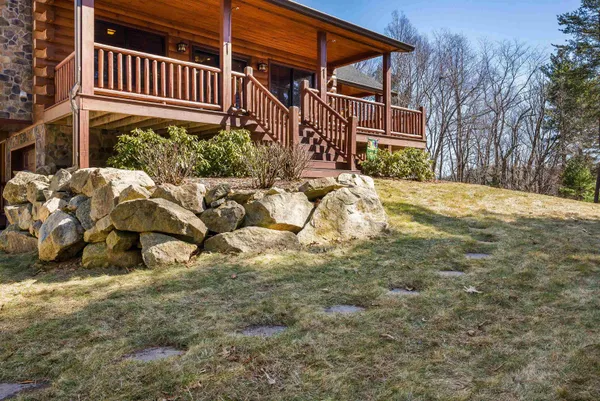 a view of a porch with wooden floor and floor to ceiling window