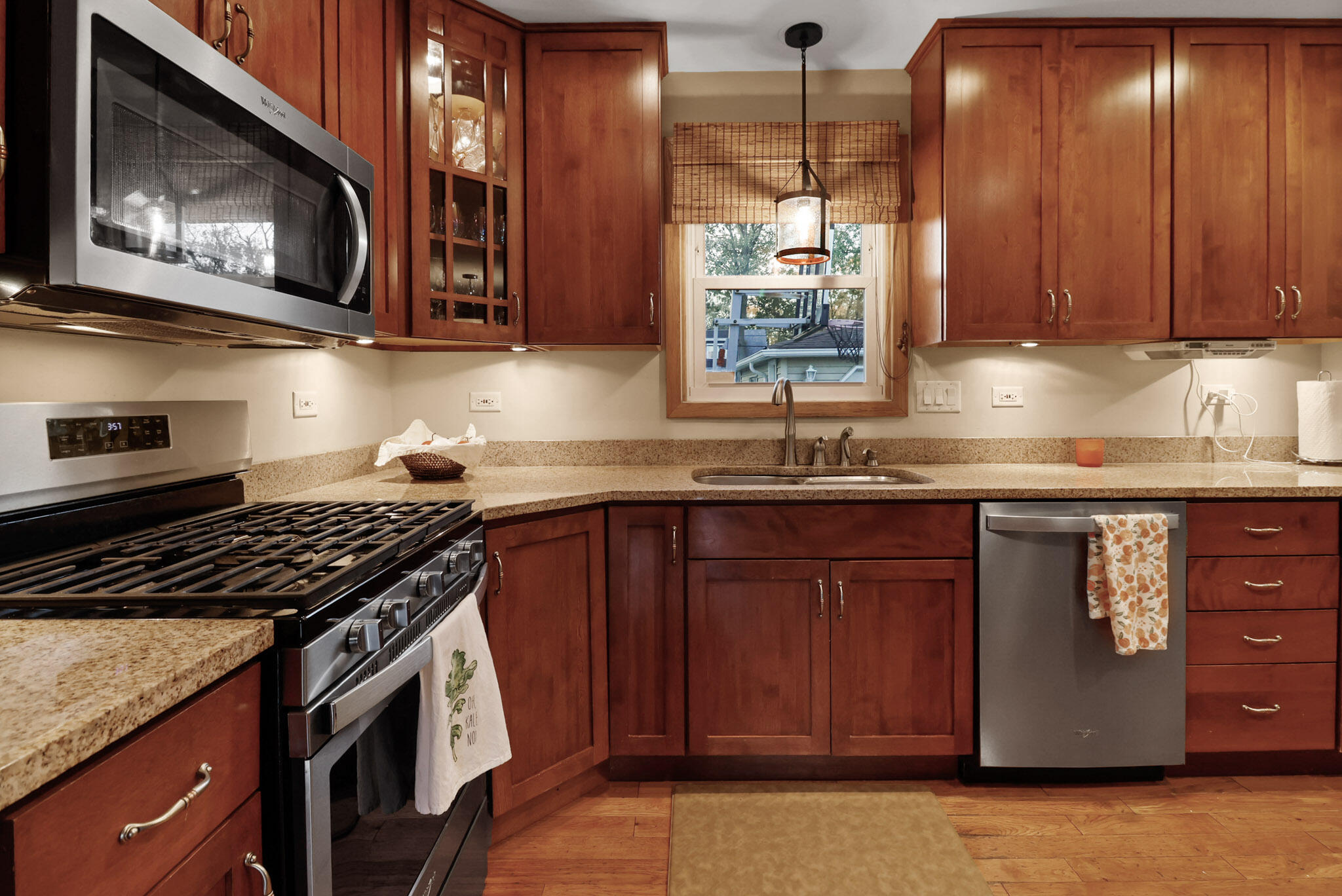 8036 Beech Avenue Munster, IN 46321 - Photo 10 of 28 a kitchen with granite countertop a stove a sink dishwasher and cabinets with wooden floor