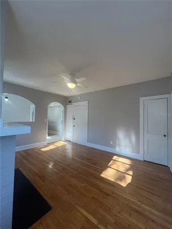 a view of empty room with wooden floor