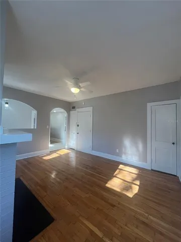 a view of empty room with wooden floor