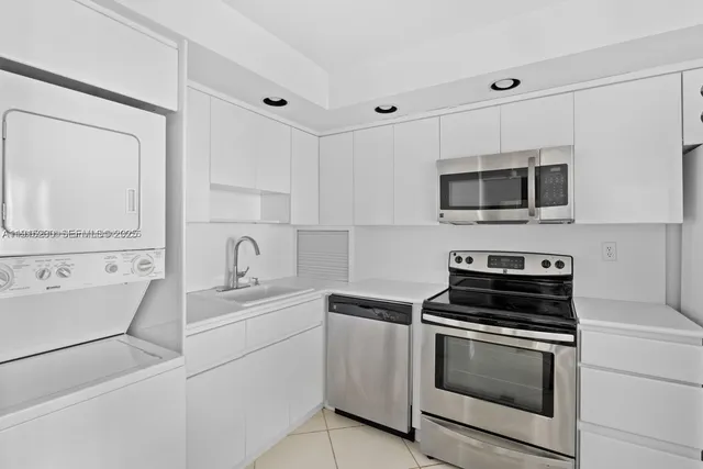 a kitchen with appliances a sink and cabinets