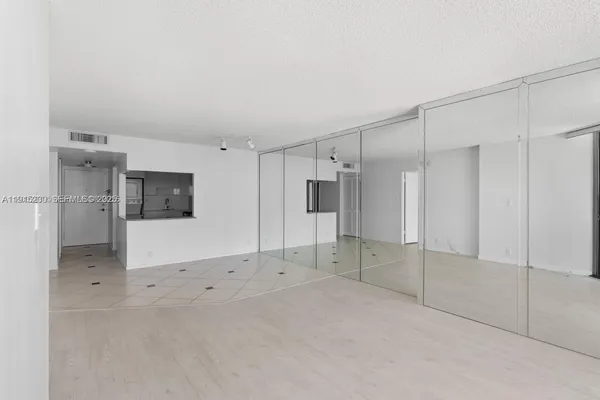 a view of empty room with a refrigerator and cabinet