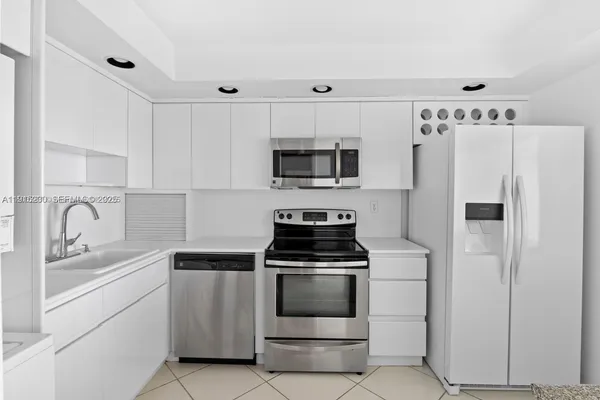 a kitchen with white cabinets and stainless steel appliances