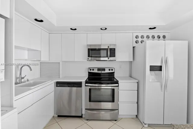 a kitchen with white cabinets and stainless steel appliances