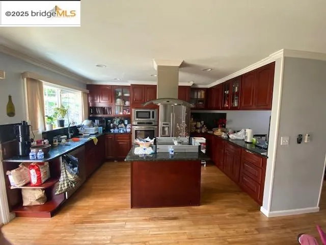 a kitchen with stainless steel appliances kitchen island granite countertop a stove a sink and a refrigerator