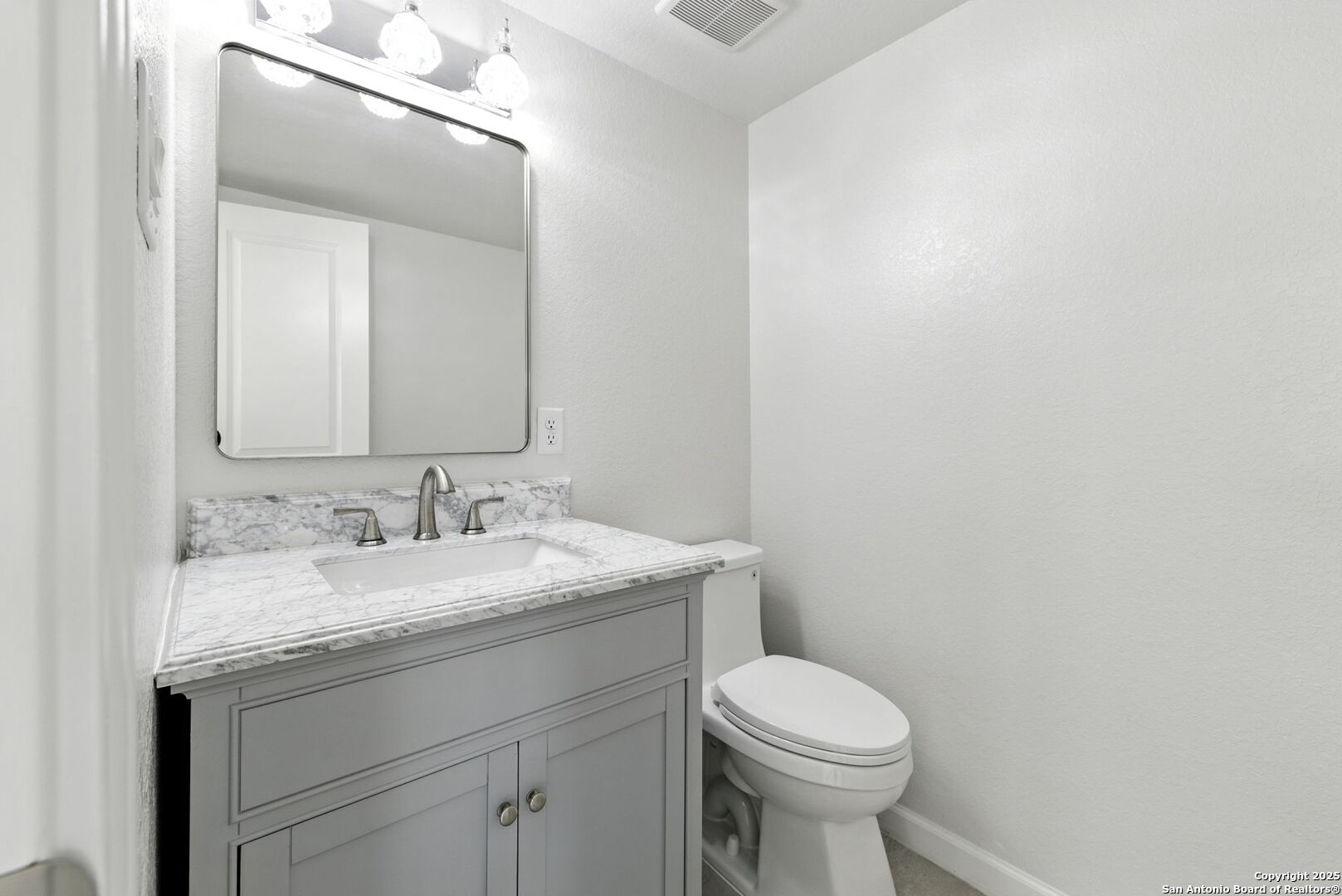 774 County Road 6843 Lytle, TX 78052 - Photo 20 of 63 a bathroom with a granite countertop toilet sink and mirror