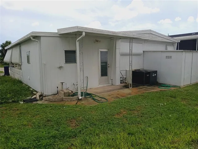 a backyard of a house with table and chairs