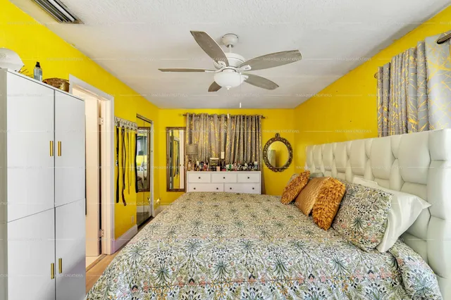 a bedroom with a bed a window and potted plant on the table