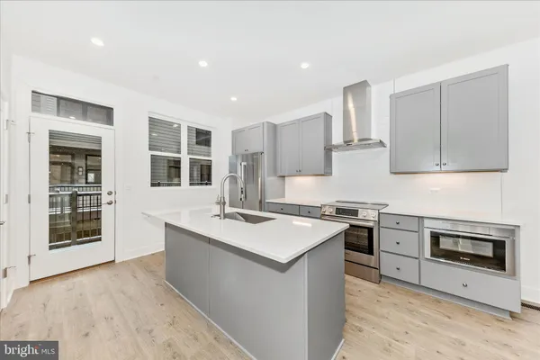 a kitchen with stainless steel appliances granite countertop a stove sink and cabinets