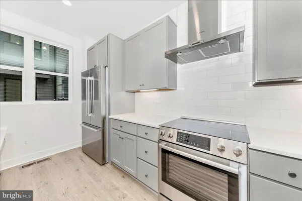 a kitchen with stainless steel appliances granite countertop a refrigerator and a stove