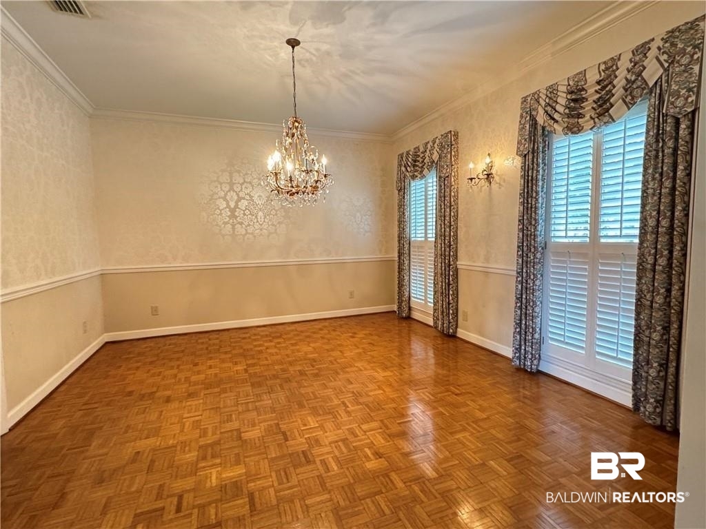 3932 Mcgregor Court Mobile, AL 36608 - Photo 6 of 9 Empty room with parquet floors, ornamental molding, and a notable chandelier