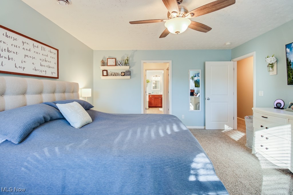 132 Timber Ridge Drive, Unit RDR Elyria, OH 44035 - Photo 28 of 41 Carpeted bedroom featuring connected bathroom, ceiling fan, and a textured ceiling