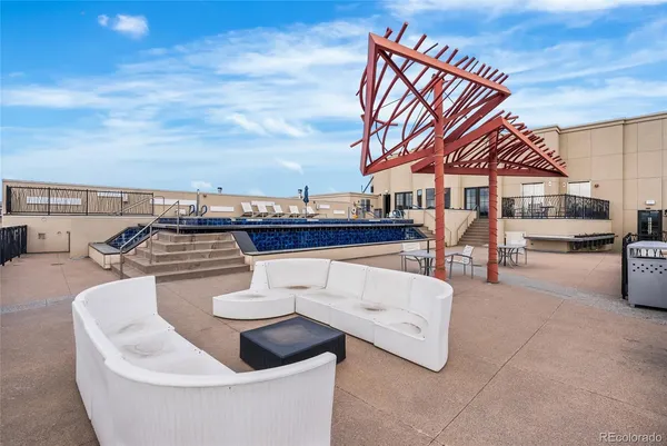 a view of roof deck with couches and sky view