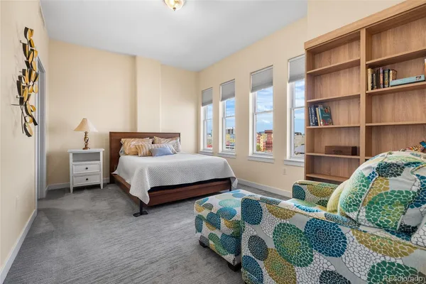 a bedroom with bed and a book shelf