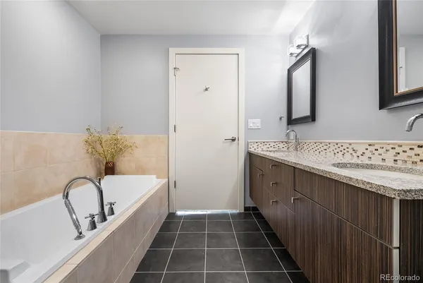 a bathroom with a tub sink and mirror