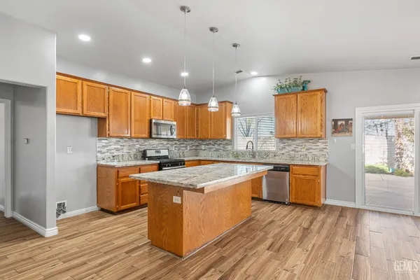 a kitchen with stainless steel appliances granite countertop wooden cabinets and a granite counter tops