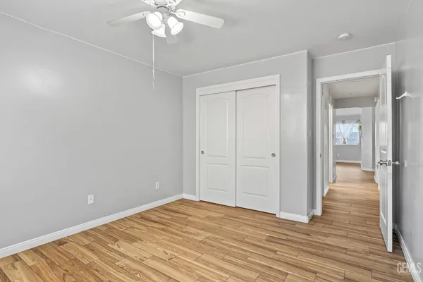 a view of a room with wooden floor and ceiling fan