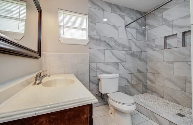 a white toilet sitting next to a bathroom sink