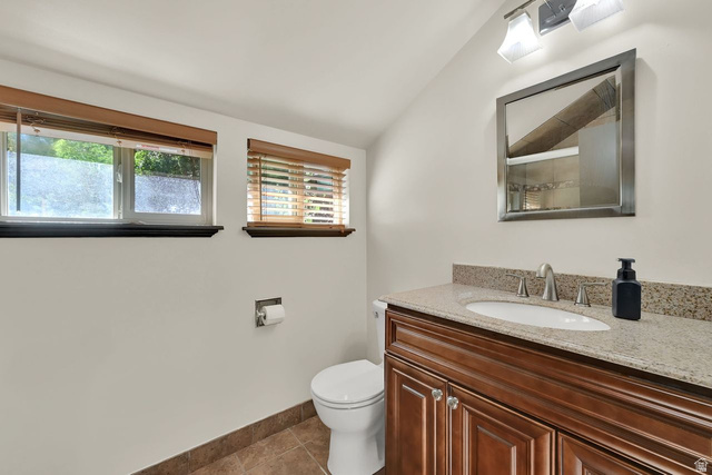 655 Ogden Canyon Road Ogden, UT 84401 - Photo 25 of 50 Bathroom featuring a wood-finish vanity with a light-toned countertop, an undermount sink, and a brushed nickel faucet