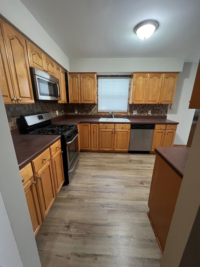 655 Nichole Lane Geneva, IL 60134 - Photo 4 of 11 a kitchen with stainless steel appliances granite countertop a stove a sink and a refrigerator