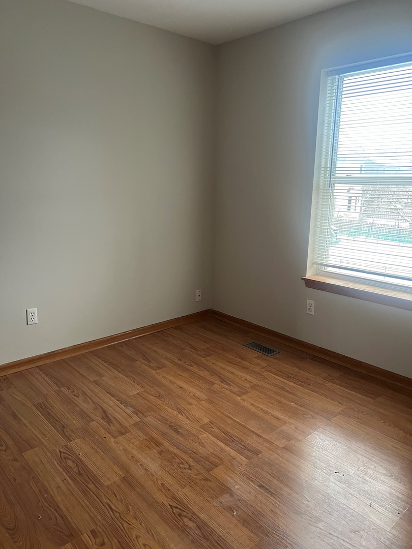655 Nichole Lane Geneva, IL 60134 - Photo 6 of 11 an empty room with wooden floor and windows
