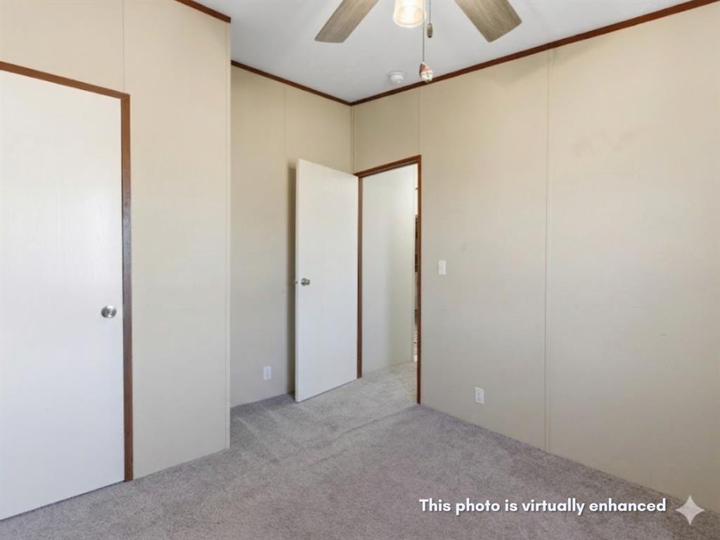 2722 Denver Road Sunset, TX 76270 - Photo 13 of 19 Carpeted interior space featuring neutral wall panels and contrasting dark wood trim