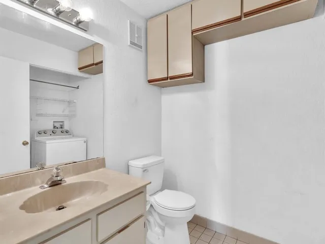 an empty room with wooden floor chandelier fan and windows