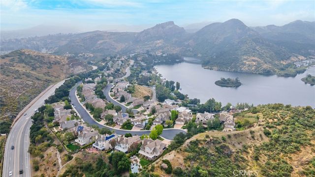 an aerial view of a house with a mountain in the background
