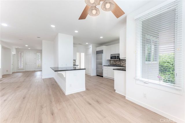 a view of kitchen with kitchen island wooden floors appliances and cabinets
