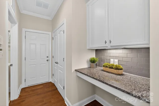 a kitchen with granite countertop white cabinets and a sink