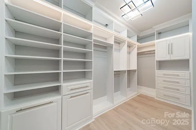 a view of walk in closet with empty racks