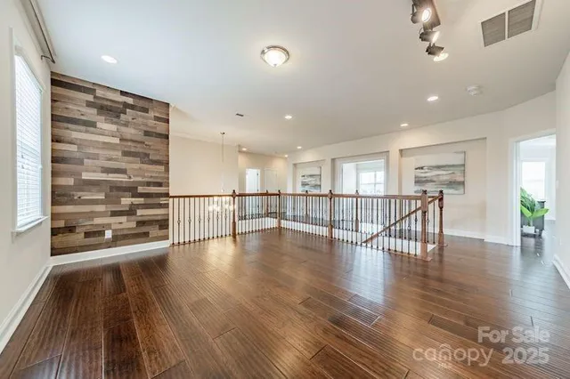 a view of a living room and kitchen with furniture wooden floor and windows