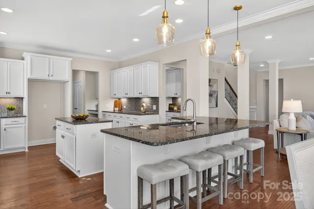 a kitchen with granite countertop a sink a counter top space and stainless steel appliances
