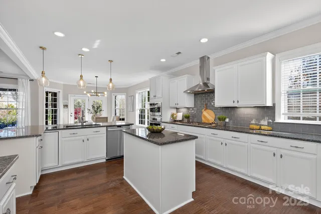 a kitchen with granite countertop a sink and white cabinets