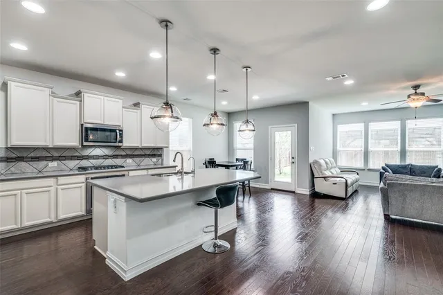 a kitchen with sink stove and wooden floor