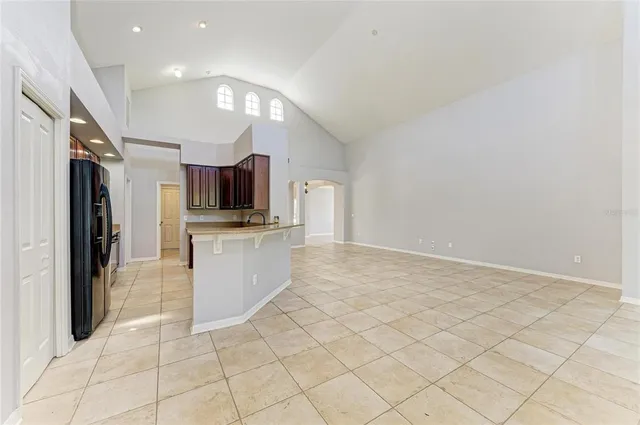 a room with a refrigerator a sink and a mirror