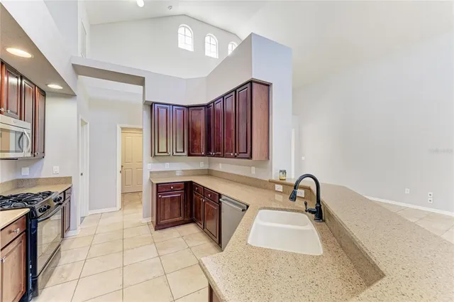 a kitchen with granite countertop cabinets stainless steel appliances and a sink