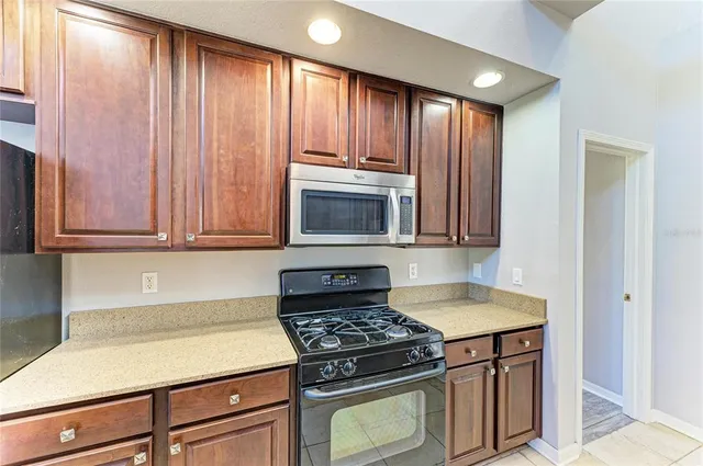 a kitchen with stainless steel appliances granite countertop a stove a sink and a microwave