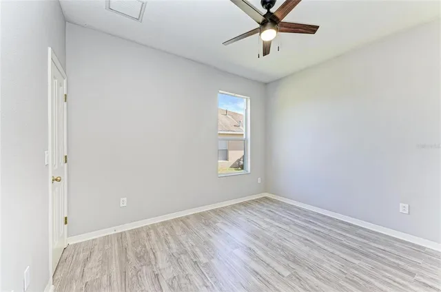 an empty room with a window and wooden floor
