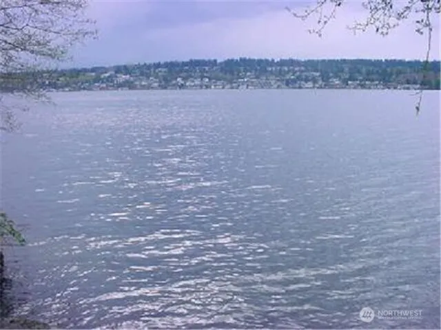 a view of lake with mountain and city in the background