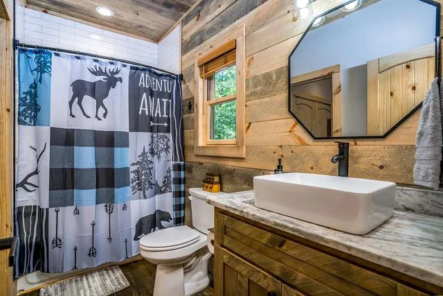 a kitchen with stainless steel appliances granite countertop a sink a stove a refrigerator cabinets and a window