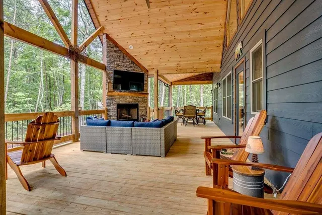 a living room with furniture a fireplace and a floor to ceiling window