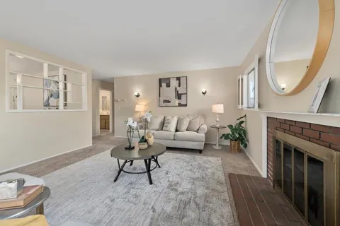 a living room with furniture a mirror and a fireplace