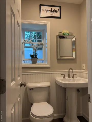 a bathroom with a toilet sink and mirror