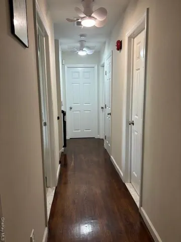 a view of a hallway with wooden floor and closet