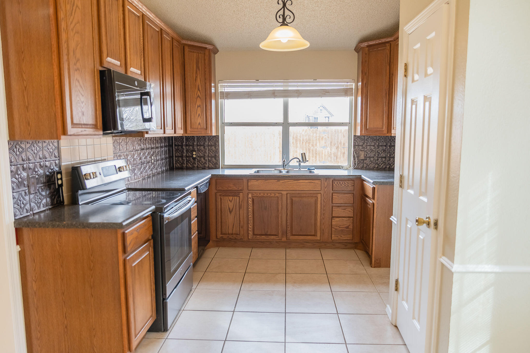 2120 93rd Street Lubbock, TX 79423 - Photo 13 of 32 a kitchen with stainless steel appliances granite countertop a stove a sink and a refrigerator