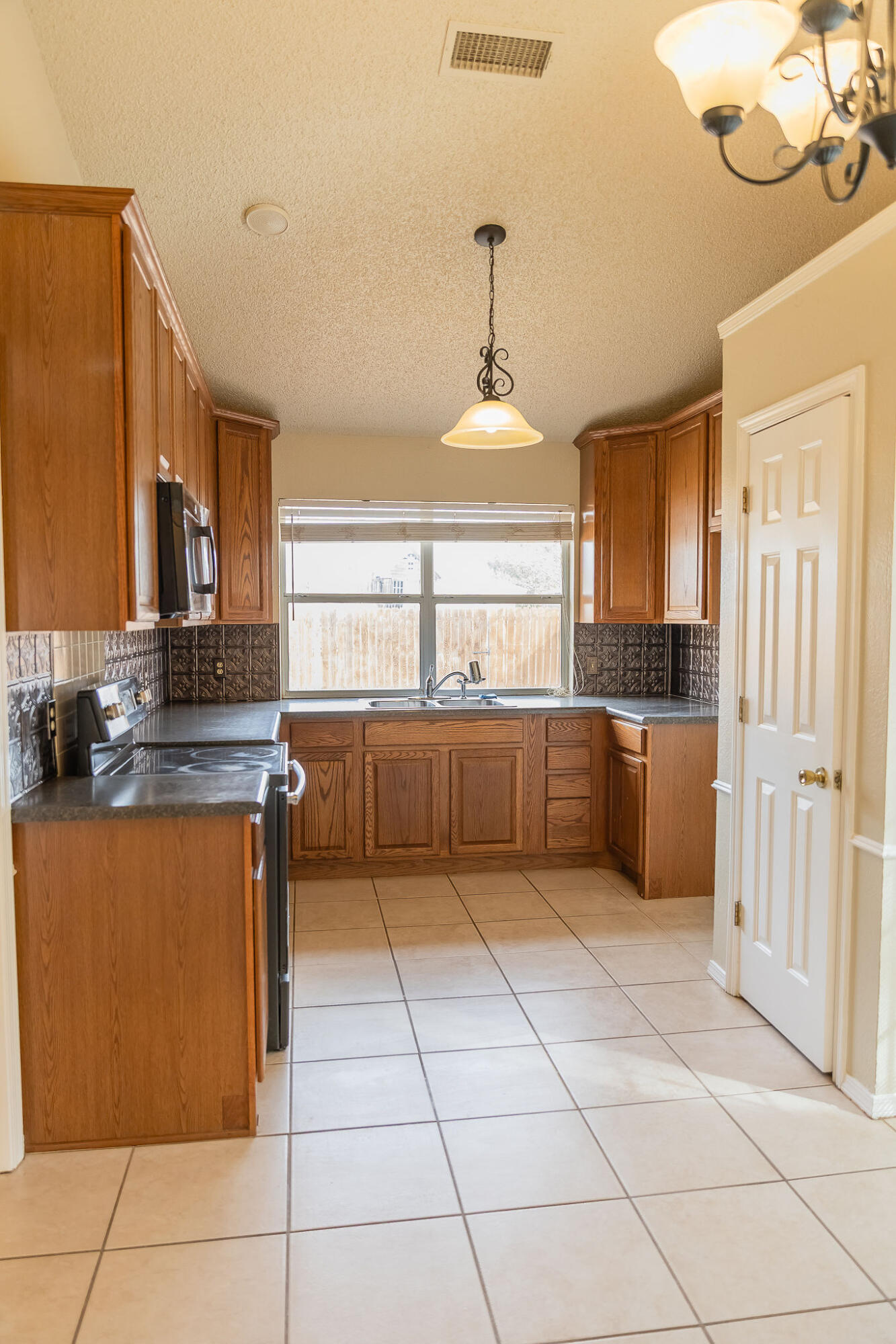2120 93rd Street Lubbock, TX 79423 - Photo 14 of 32 a kitchen with stainless steel appliances granite countertop a sink and a refrigerator